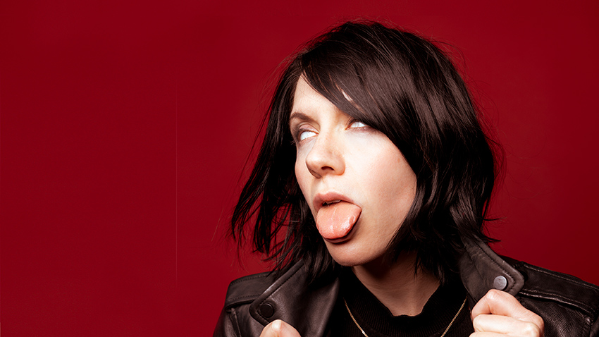 K.Flay posing with her tongue out and eyes rolled back
