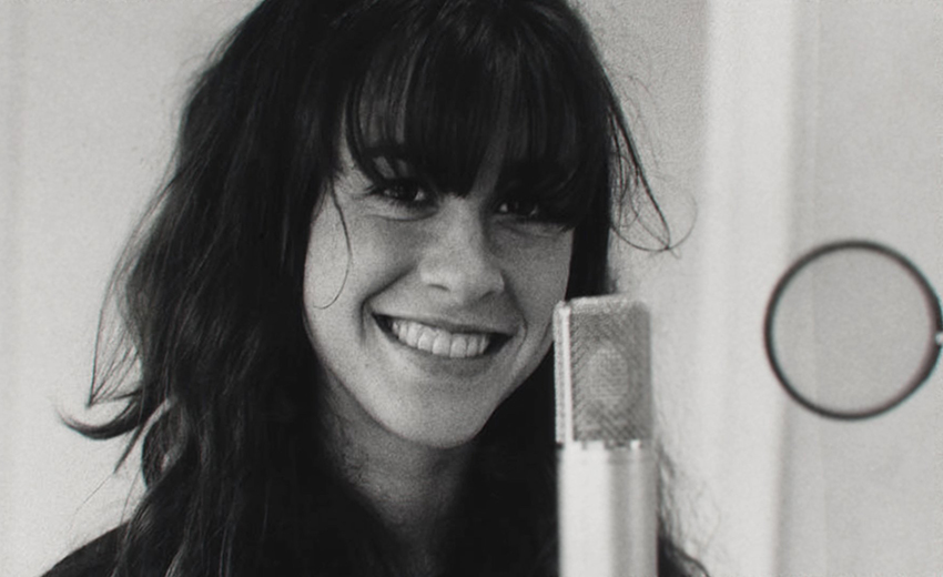 A black and white photo of young Alanis Morrisette.