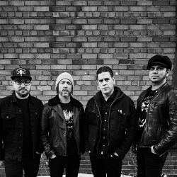 Billy Talent band standing in front of a brick wall, shot in black and white.
