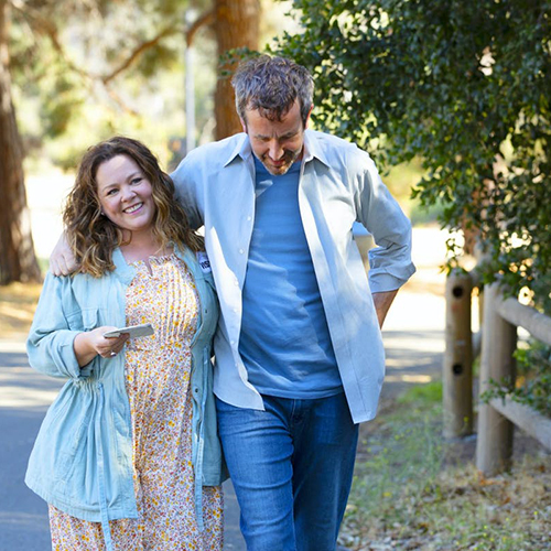 Melissa McCarthy and Chris O'Dowd walking with their arms around each other's backs.