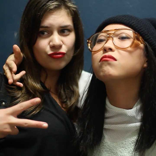 Awkwafina giving a sideways peace sign to the camera.