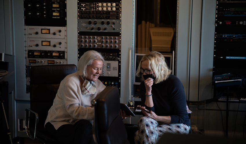 Agnetha Fältskog and Frida Lyngstad of ABBA sitting together in the recording studio.