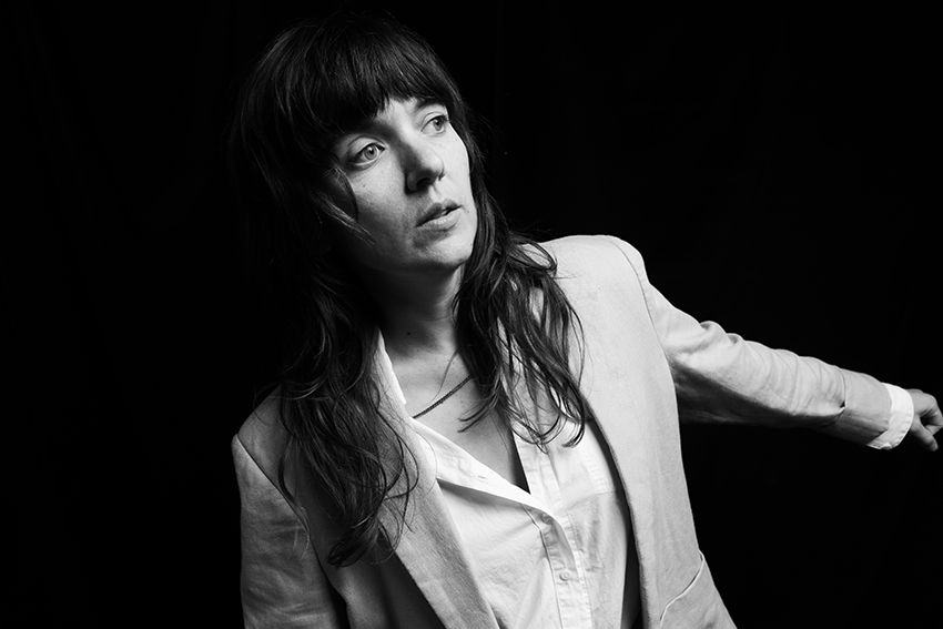 Black and white photo of Courtney Barnett as she looks off to the right.