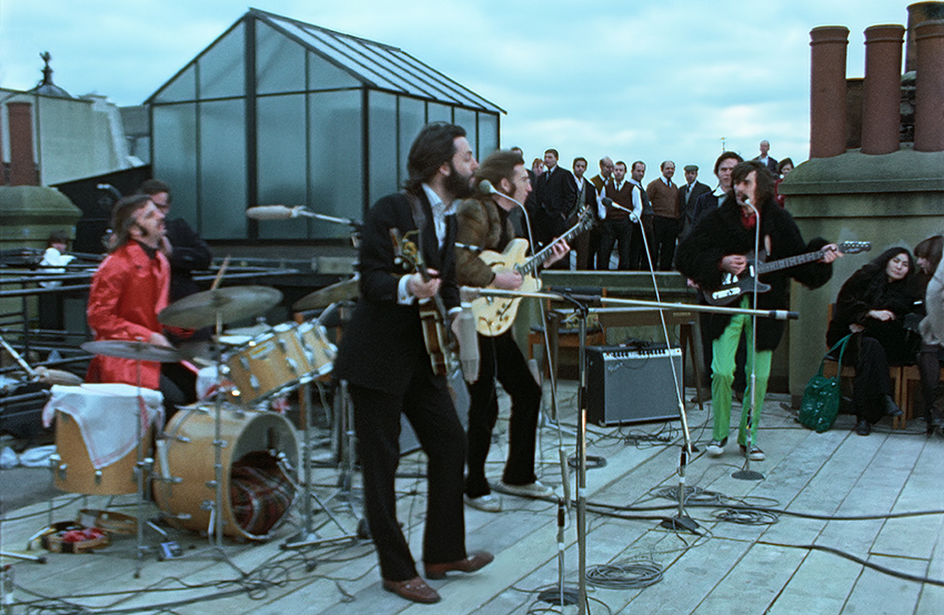 The Beatles performing on a rooftop.