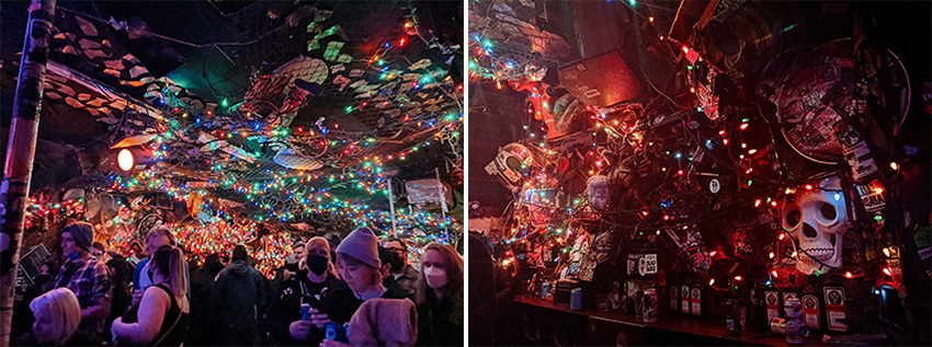 Interior decor of the Bovine Sex Club - a mix of Christmas lights strung on the ceiling and across the back bar, with car parts and doll heads strewn about.