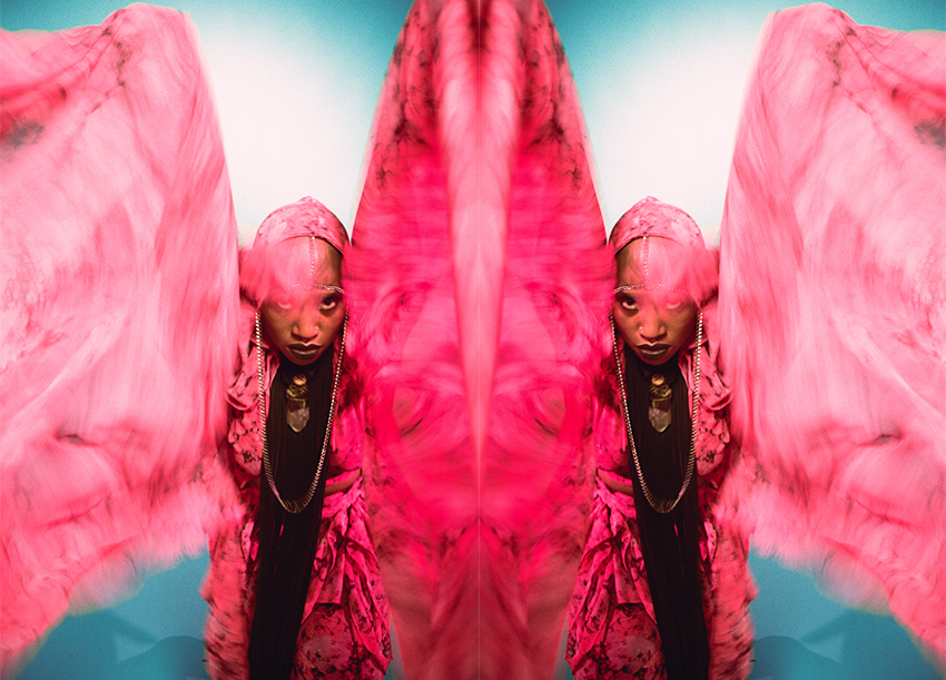 SATE wearing bright pink feather wings stretched out towards the camera.
