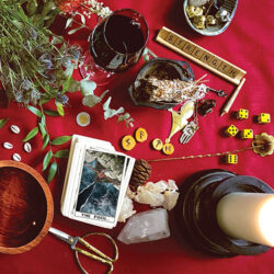 Sate's album cover for The Fool — an overhead shot of a tabletop scattered with a glass of red wine, candle, tarot cards and other objects.