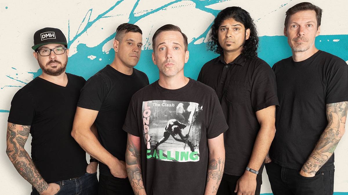 Billy Talent standing against a painted wall.