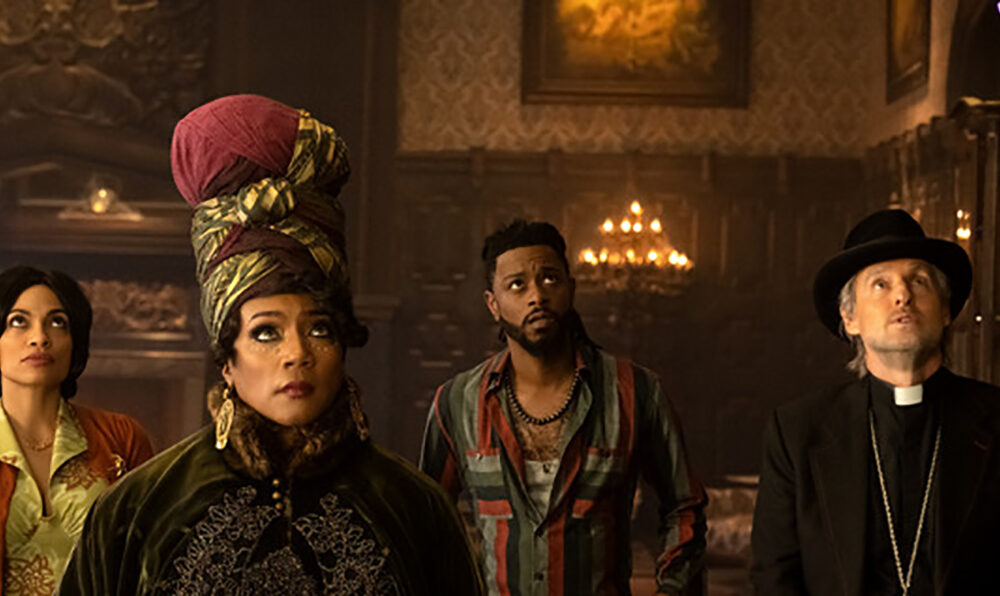 (L-R): Rosario Dawson as Gabbie, Tiffany Haddish as Harriet, LaKeith Stanfield as Ben, and Owen Wilson as Father Kent searching for a plot in Disney's live-action HAUNTED MANSION. Photo Jalen Marlowe