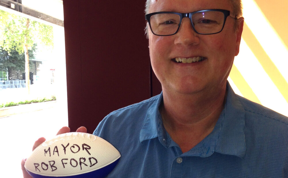 SXSW co-founder Roland Swenson shows off “autographed” football he was offered in lieu of then-Torornto mayor Rob Ford actually showing up for scheduled meeting during 2013 Music City trip to Austin, TX.